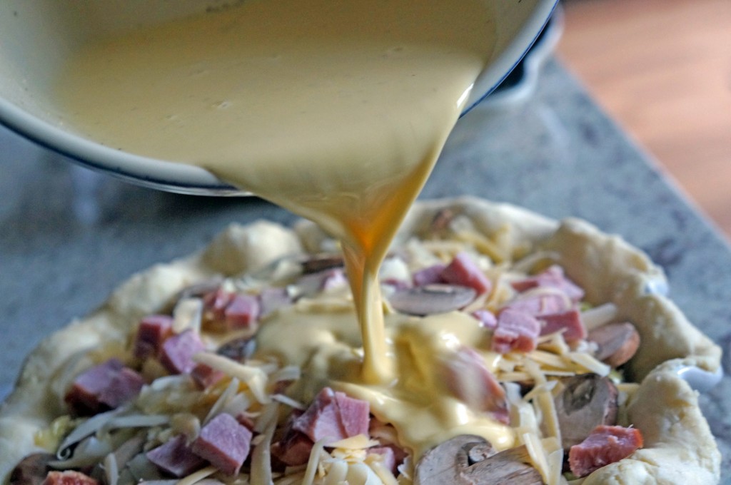 pouring eggs into quiche